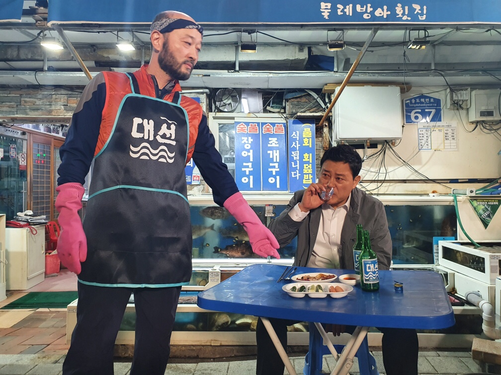 대선소주와 대선 앞치마가 소품으로 사용된 서태화·지대한 주연의 장편영화 ‘하우치’. [부산영상위원회 제공]