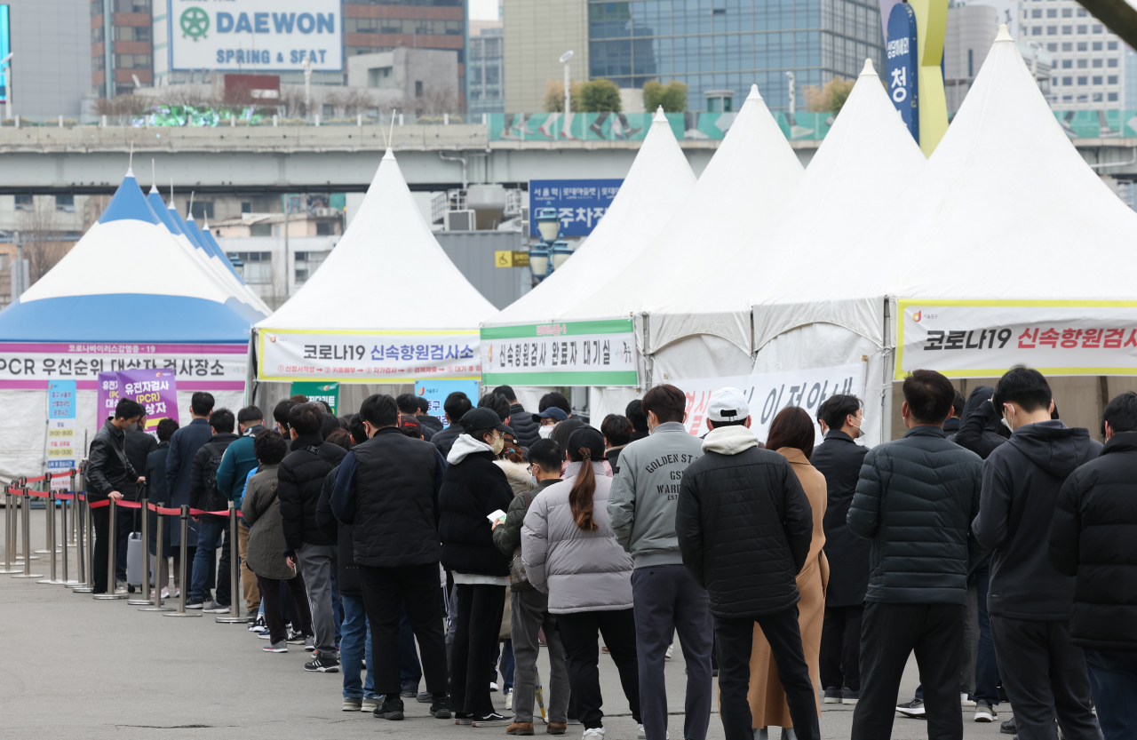23일 오전 서울역광장에 마련된 코로나19 임시 선별검사소에 시민들이 검사를 받기 위해 줄을 서서 기다리고 있다. [연합]