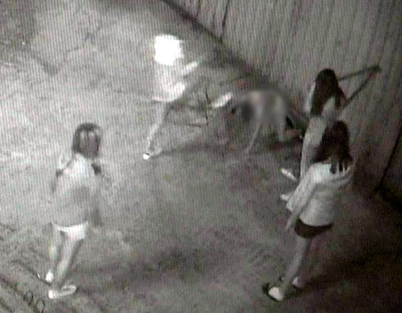In surveillance camera footage, a schoolgirl victim is on her hands and knees as she is kicked in the head by one of four attackers. (Yonhap)
