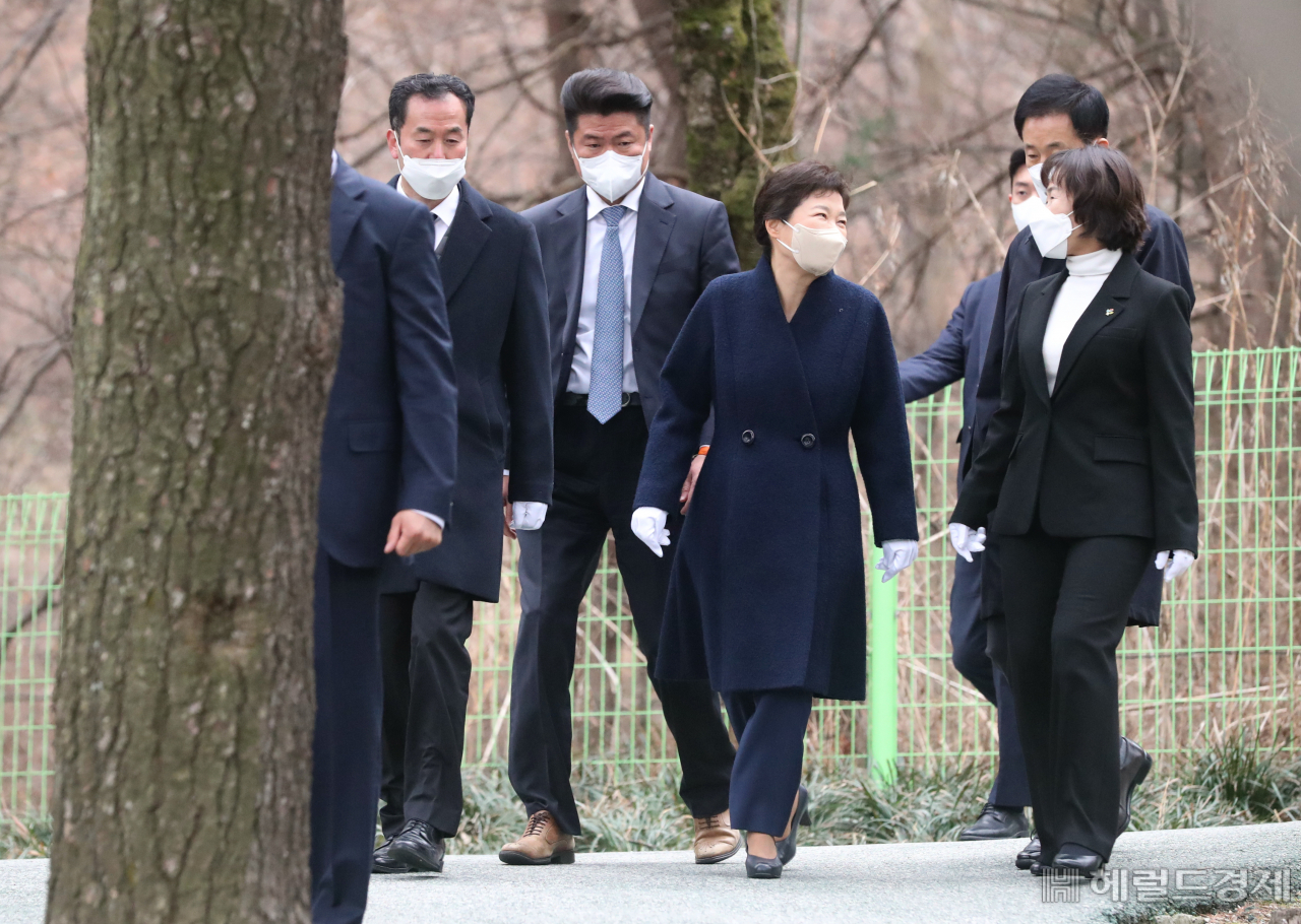 24일 오전 퇴원한 박근혜 전 대통령이 국립서울현충원 박정희 전 대통령의 묘소 참배를 마치고 경호원의 호위를 받으며 유영하 변호사와 함께 걸어 내려오고 있다. 이상섭 기자