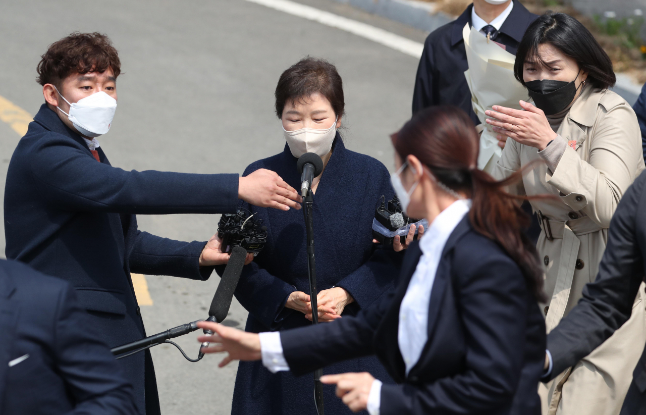 24일 오후 박근혜 전 대통령이 대구 달성군 사전에 도착해 대국민 담화문을 밝히던 중 갑자기 소주병이 날아들자 경호원들이 박 전 대통령을 에워싸고 있다. [연합]