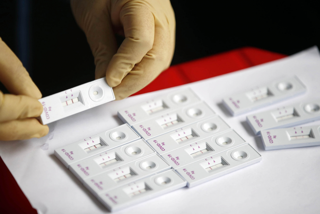 A medical worker checks the result of a rapid antigen COVID-19 test at a makeshift testing station in the southwestern city of Gwangju on Friday, in this photo provided by the local government. (Yonhap)