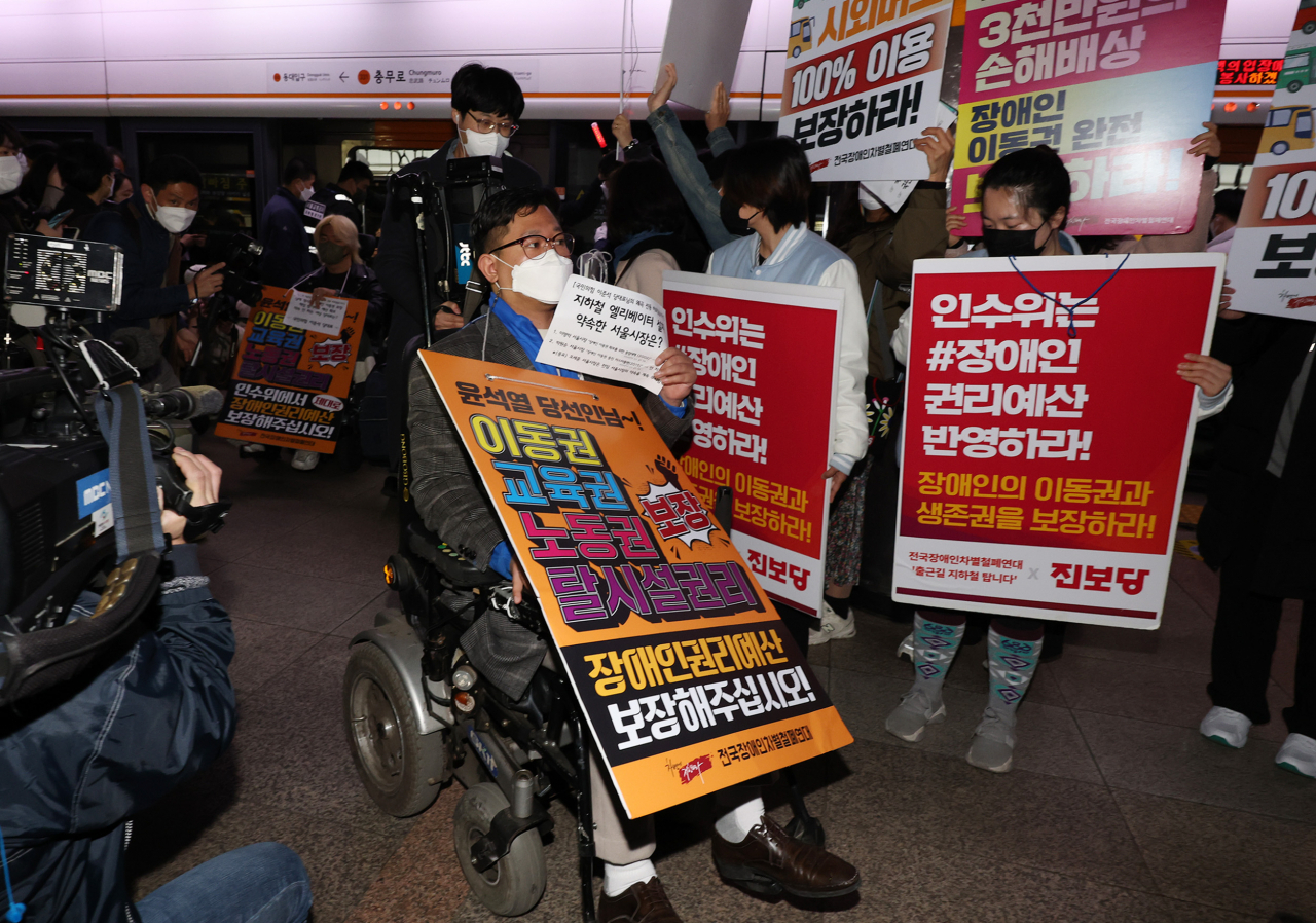 전국장애인차별철폐연대(전장연) 등 장애인단체 회원들이 28일 서울 충무로역 3호선 승강장에서 장애인 이동권 보장·장애인 권리예산 반영을 요구하며 출근 시간대 지하철 시위를 하고 있다. [연합]