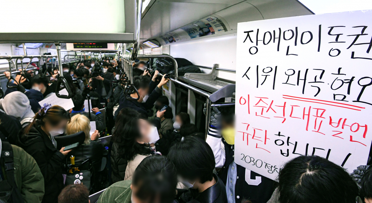 전국장애인차별철폐연대(전장연) 회원들과 시민단체가 28일 서울 3호선 지하철에서 장애인 이동권 보장·장애인 권리예산 반영을 요구하며 출근 시간대 지하철 시위 '출근길 지하철 탑니다'를 하고 있다. [연합]