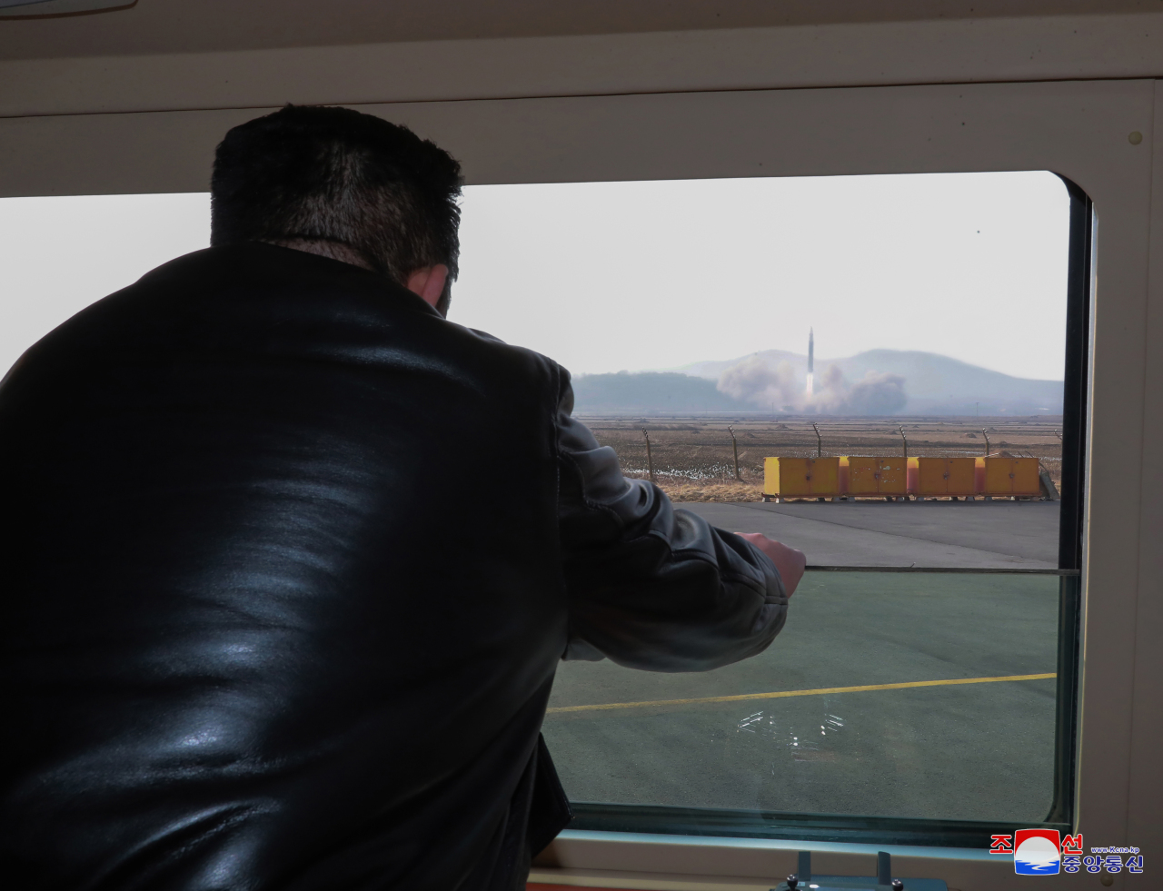North Korean leader Kim Jong-un watches a Hwasong-17 intercontinental ballistic missile (ICBM) being launched from Pyongyang International Airport on March 24, 2022, in this photo released by North Korea's official Korean Central News Agency.(Yonhap)
