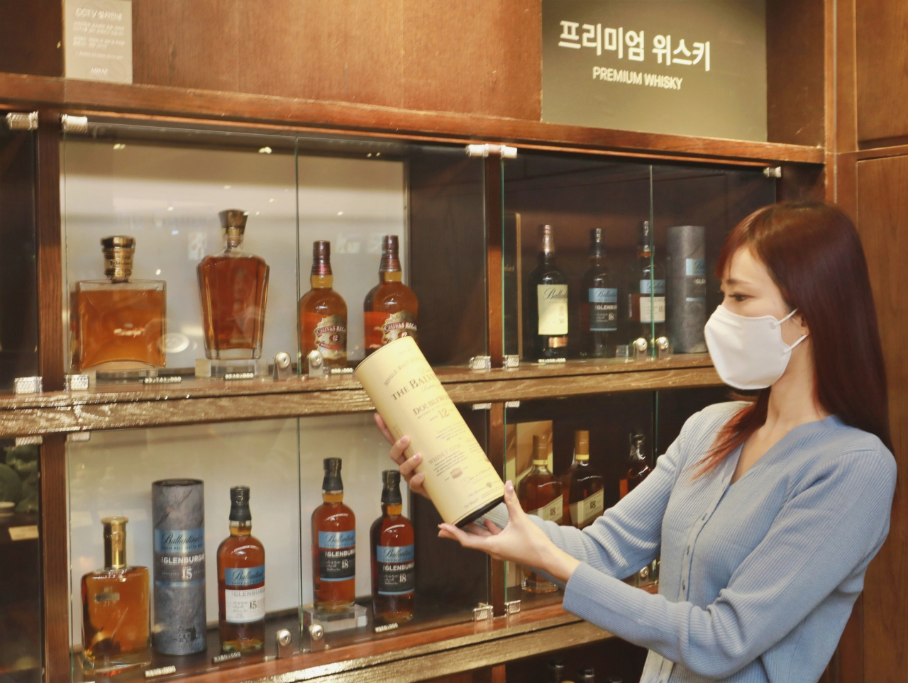롯데백화점 본점 주류 매장에서 한 고객이 위스키를 구경하고 있다. [롯데백화점 제공]