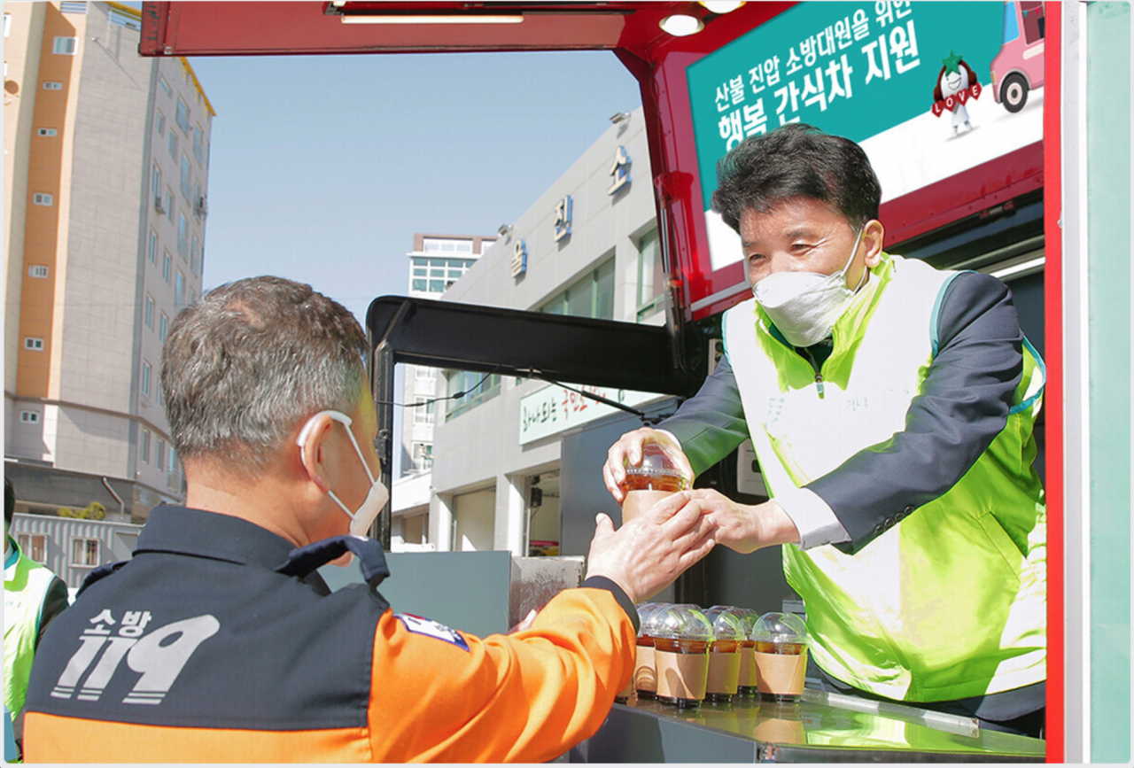 함영주 회장(사진 오른쪽)이 울진소방서에 지원한 간식 차량에 직접 올라 타 소방대원에게 커피를 전달하고 있다.[하나금융 제공]