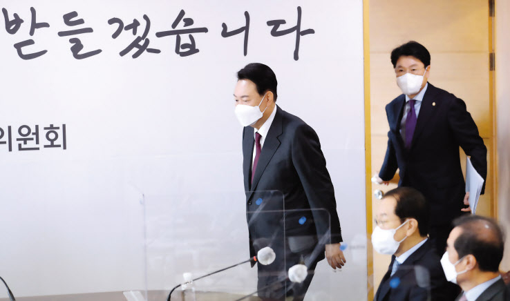 윤석열 대통령 당선인이 29일 서울 통의동 인수위원회에서 대통령직인수위원회 2차 간사단회의에 참석하기 위해 회의실로 입장하고 있다. 뒤로 ‘국민의 뜻을 받들겠습니다’라는 글귀가 적혀 있다. 윤 당선인은 이날 공개된 자리에서 모두발언은 하지 않았다. 박해묵 기자