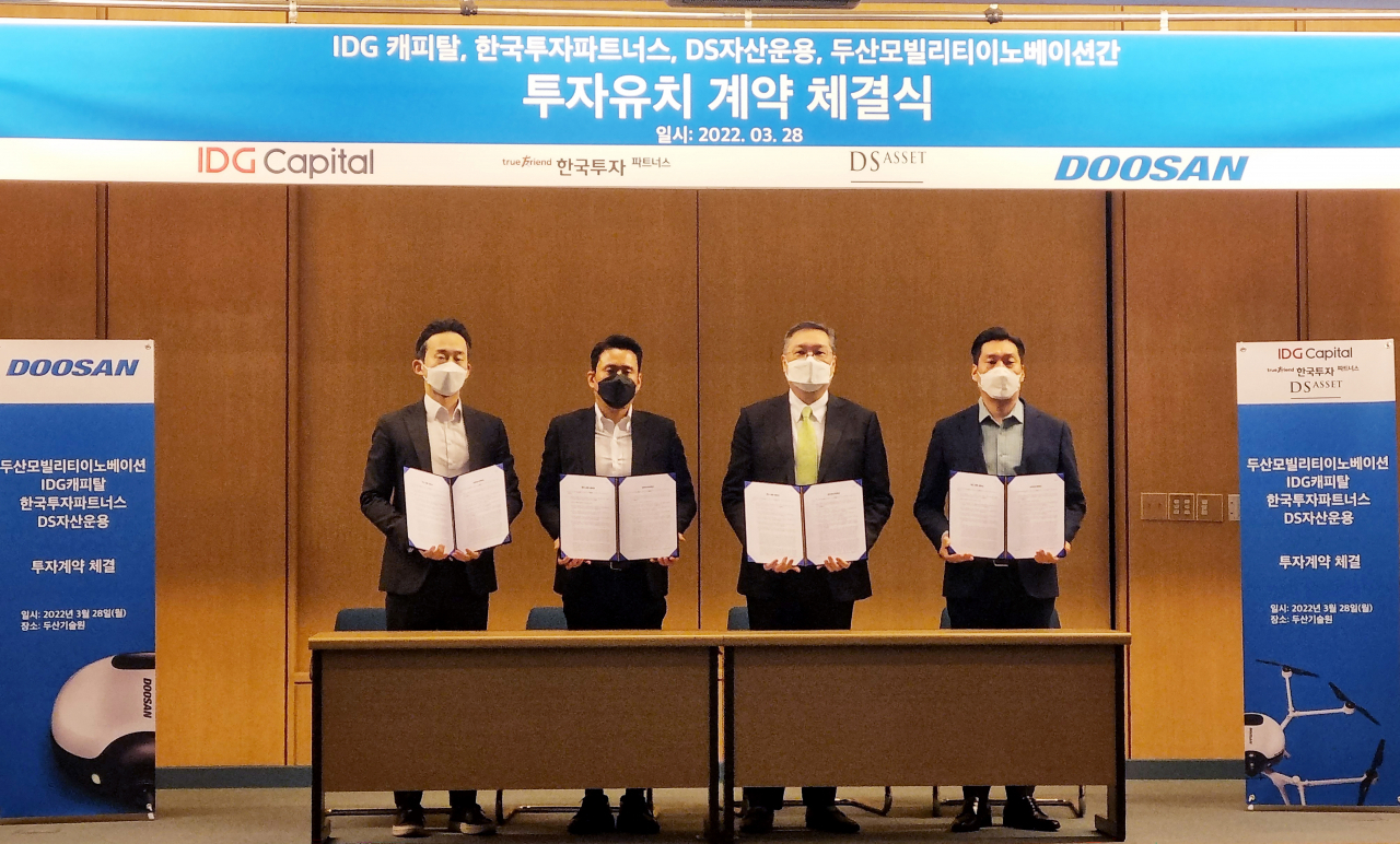 투자유치 계약 체결식에서 두산모빌리티이노베이션 이두순 대표(왼쪽 셋째)가 한국투자파트너스 장학성 본부장, IDG캐피탈 이혁진 부사장, DS자산운용 장경배 이사와 기념사진을 촬영하고 있다. [두산모빌리티이노베이션 제공]