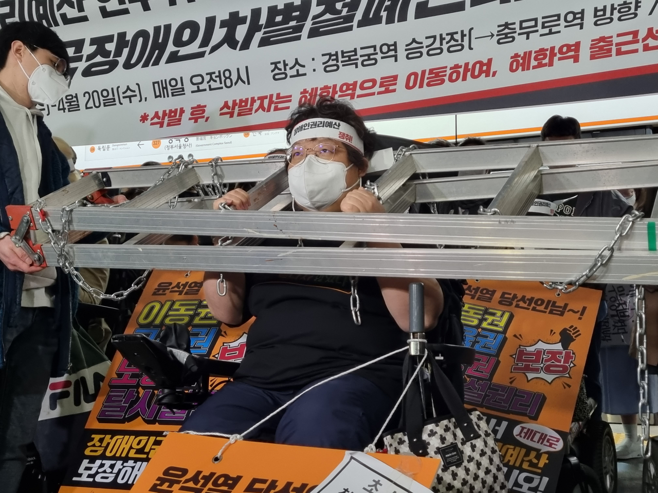 30일 이형숙 서울시장애인자립생활센터협의장이 2002년 9월 시청역 지하철 선로로 장애인 활동가들이 내려가 장애인 이동권 증진을 했던 것을 재현하기 위해 쇠사슬이 감긴 철제 사다리를 목에 끼우는 퍼포먼스를 보이고 있다. 김영철 기자