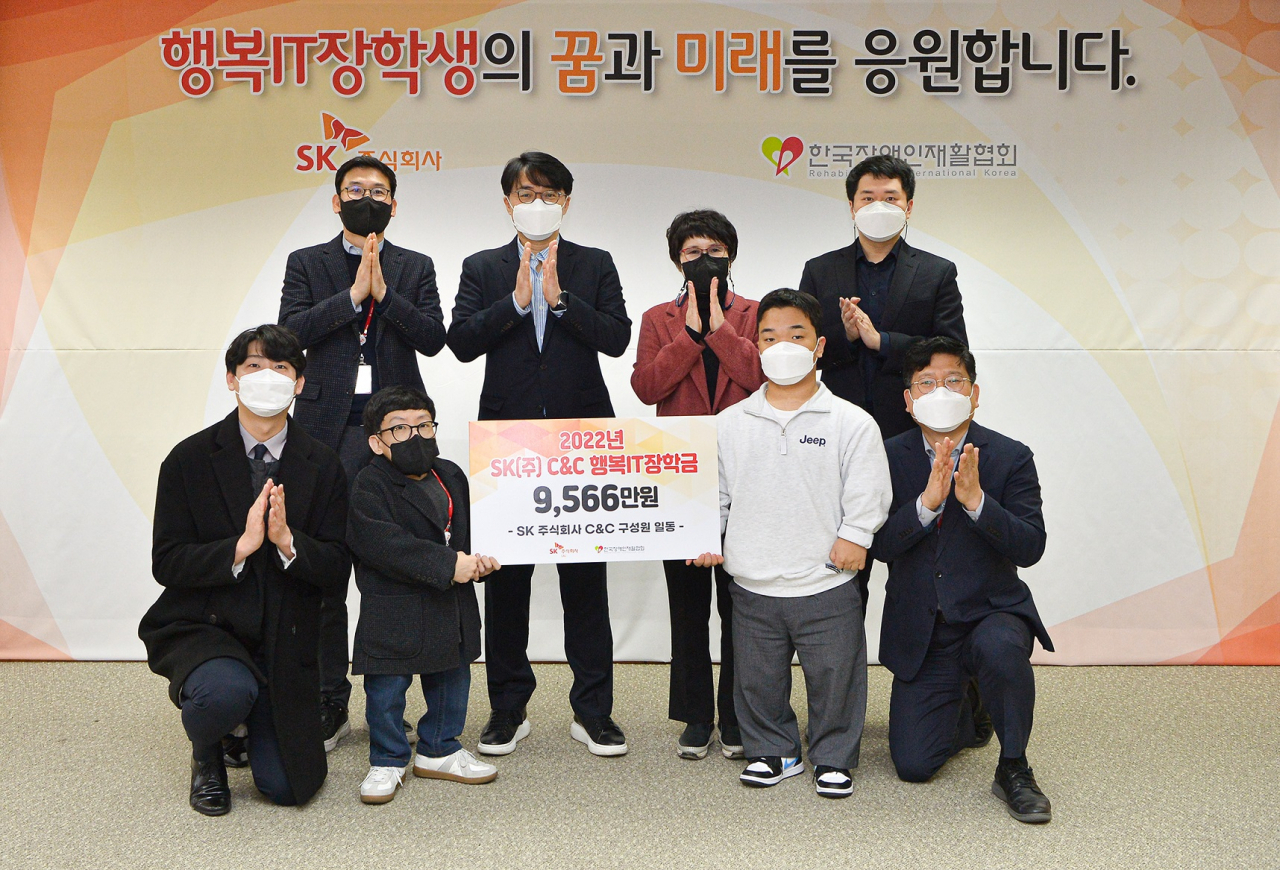 30일 경기 분당 SK-U타워에서 김성한 SK㈜ C&C SV담당(뒷줄 왼쪽 두번째)과 한국장애인재활협회 유명화 사무총장(뒷줄 왼쪽 세번째)이 '2022 행복IT장학금 전달식' 후 기념촬영 하고 있다.