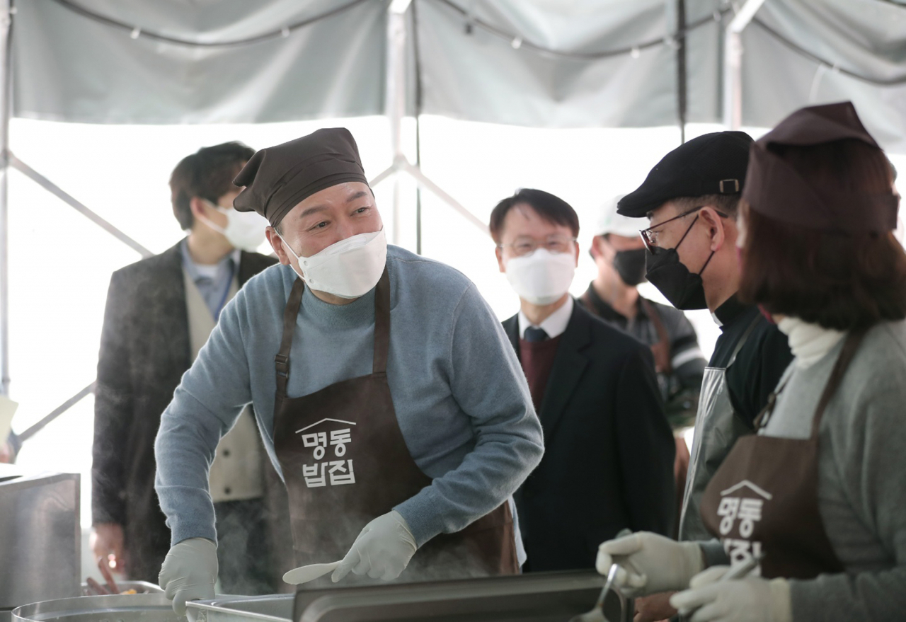 윤석열 대통령 당선인이 30일 서울 명동성당 내 무료 급식소인 명동밥집을 찾아 배식 봉사활동을 하고 있다. [연합]