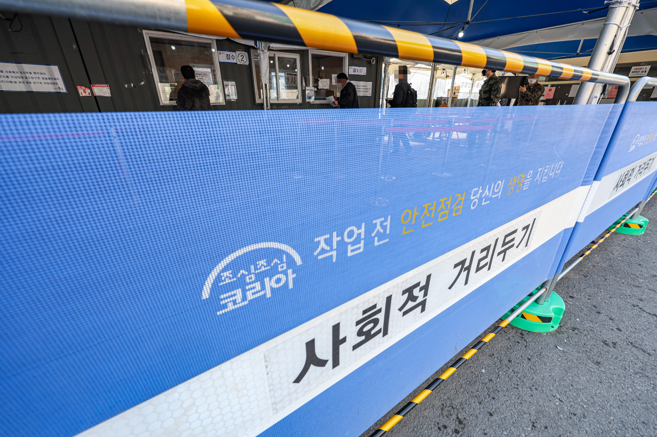 신종 코로나바이러스 감염증(코로나19) 신규 확진이 다시 큰 폭 증가한 29일 오전 서울 중구 서울역 선별진료소에 '사회적 거리두기'가 쓰인 펜스가 설치돼 있다. [연합]