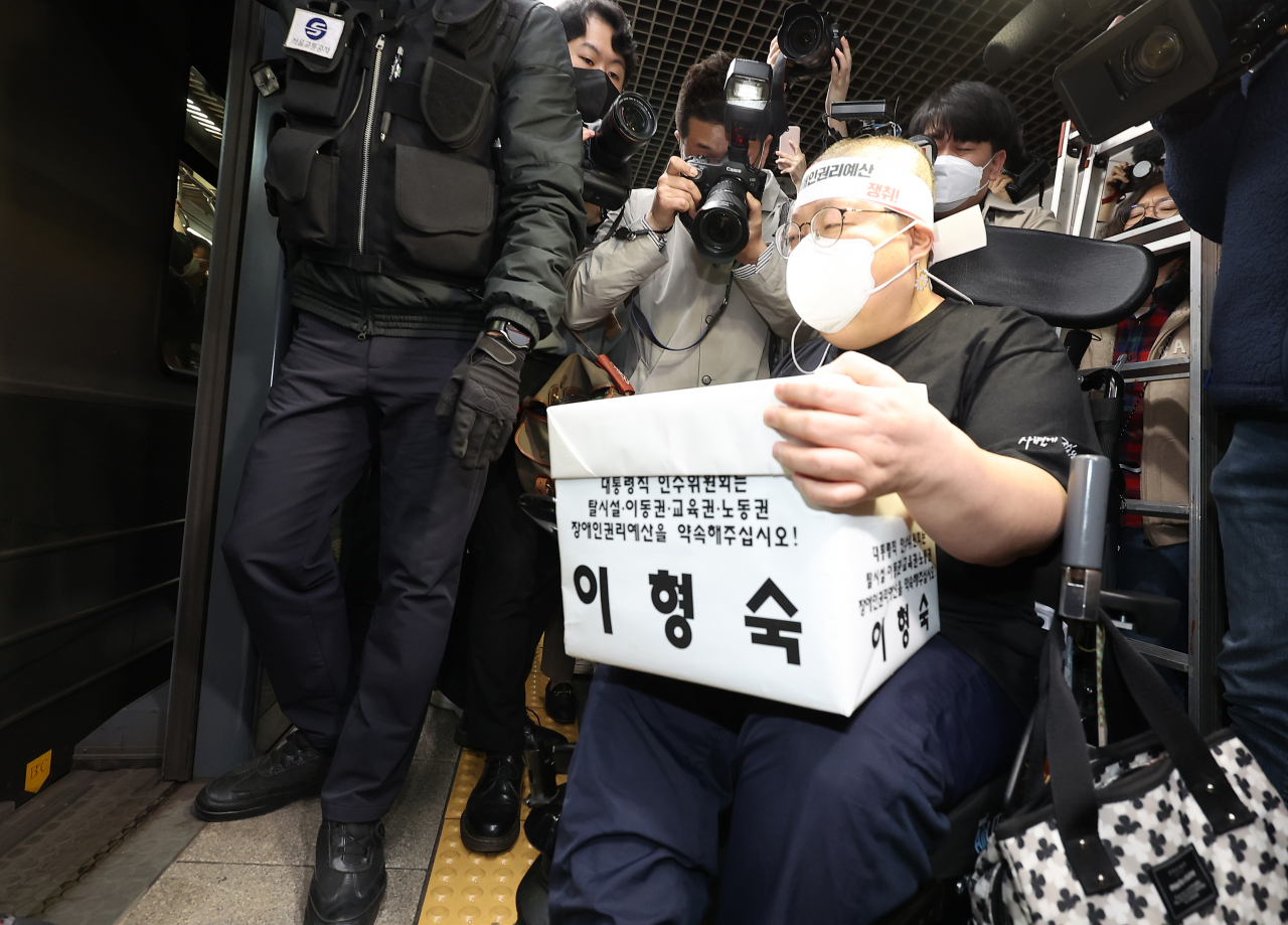 30일 오전 전국장애인차별철폐연대의 장애인권리예산 및 관련법 개정 요구에 대한 인수위 답변 촉구 삭발 투쟁 결의식을 마친 이형숙 서울시장애인자립생활센터협의회장이 서울 혜화역에서 선전전을 하기 위해 지하철로 이동하고 있다. [연합]