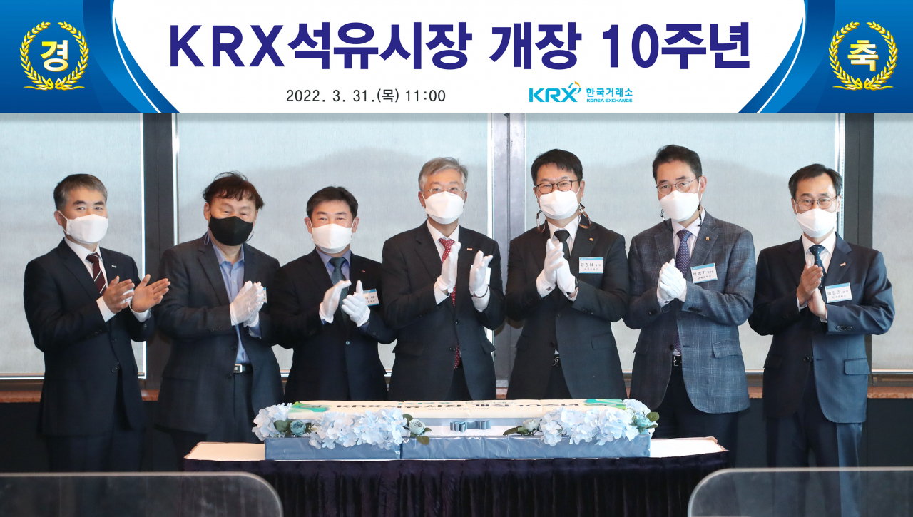 KRX석유시장 개장 10주년 기념식에 참석한 조효제 한국거래소 파생상품시장본부장(왼쪽 네번째)과 업무유공자들이 떡케이크 커팅후 기념촬영을 하고 있다. [사진=한국거래소]