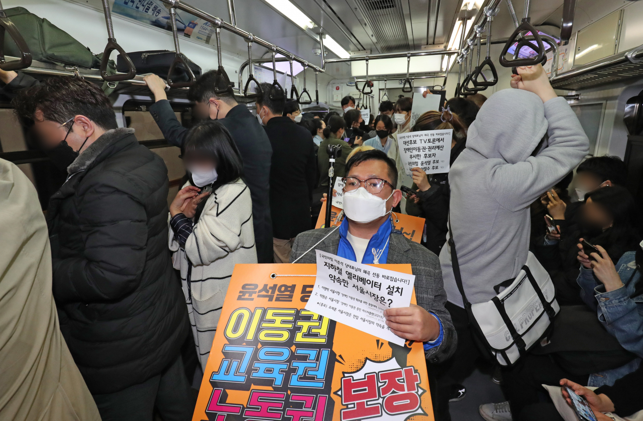 지난달 28일 오전 전국장애인차별철폐연대(전장연) 관계자들이 서울 지하철 3호선 경복궁역에서 4호선 혜화역까지 이동하는 출근길 지하철 시위를 진행하고 있다. [연합]