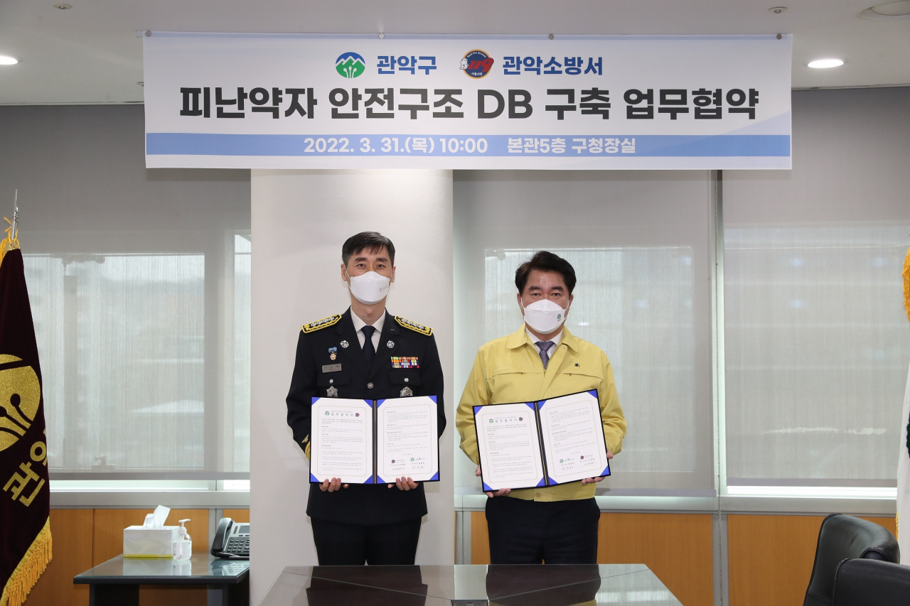 박준희(오른쪽) 서울 관악구청장은 지난달 31일 서영배 관악소방서장과 ‘피난약자 안전구조 데이터베이스(DB) 구축 사업’을 위한 업무협약을 체결한 뒤 기념촬영을 하고 있다. [관악구 제공]