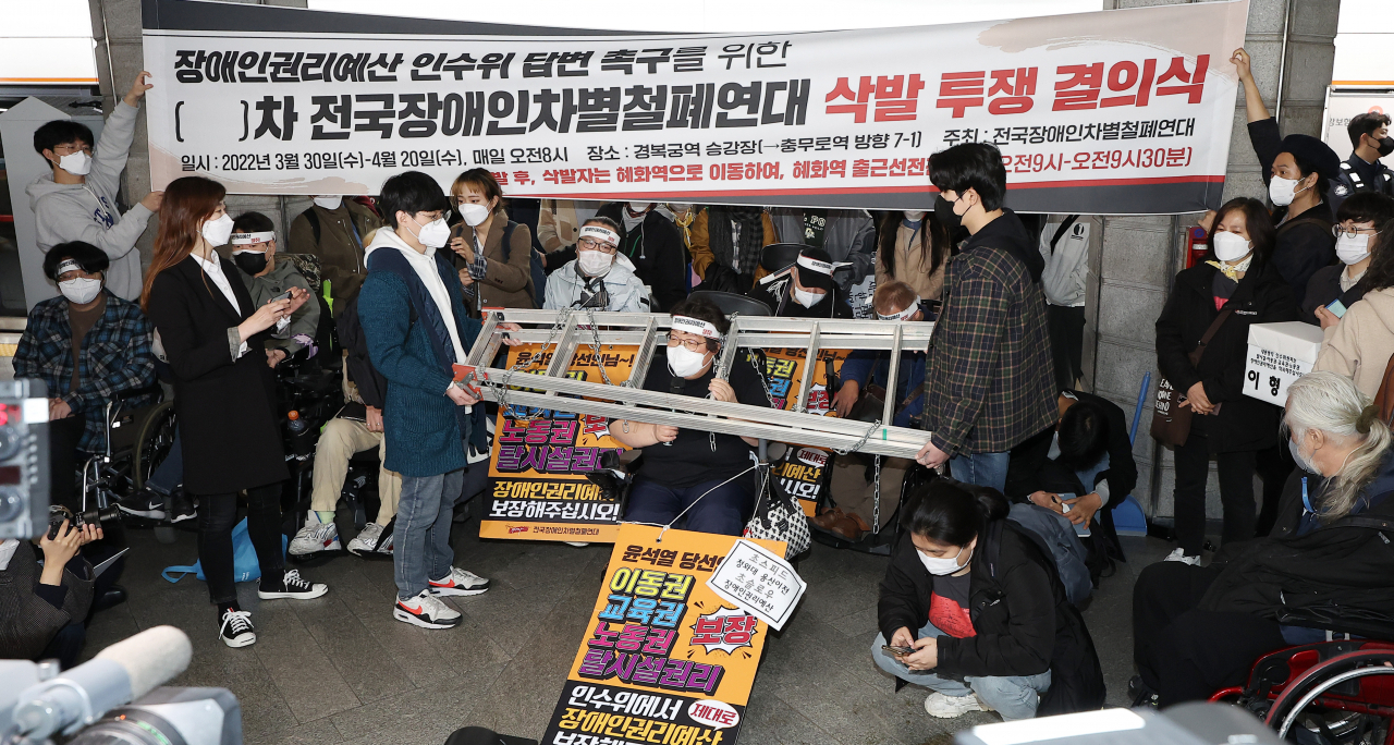 지난달 30일 오전 전국장애인차별철폐연대의 장애인권리예산 및 관련법 개정 요구에 대한 인수위 답변 촉구 삭발 투쟁 결의식이 열린 서울 종로구 지하철 3호선 경복궁역 탑승장에서 이형숙 서울시장애인자립생활센터협의회장이 삭발에 앞서 상징의식을 한 뒤 발언하고 있다. [연합]