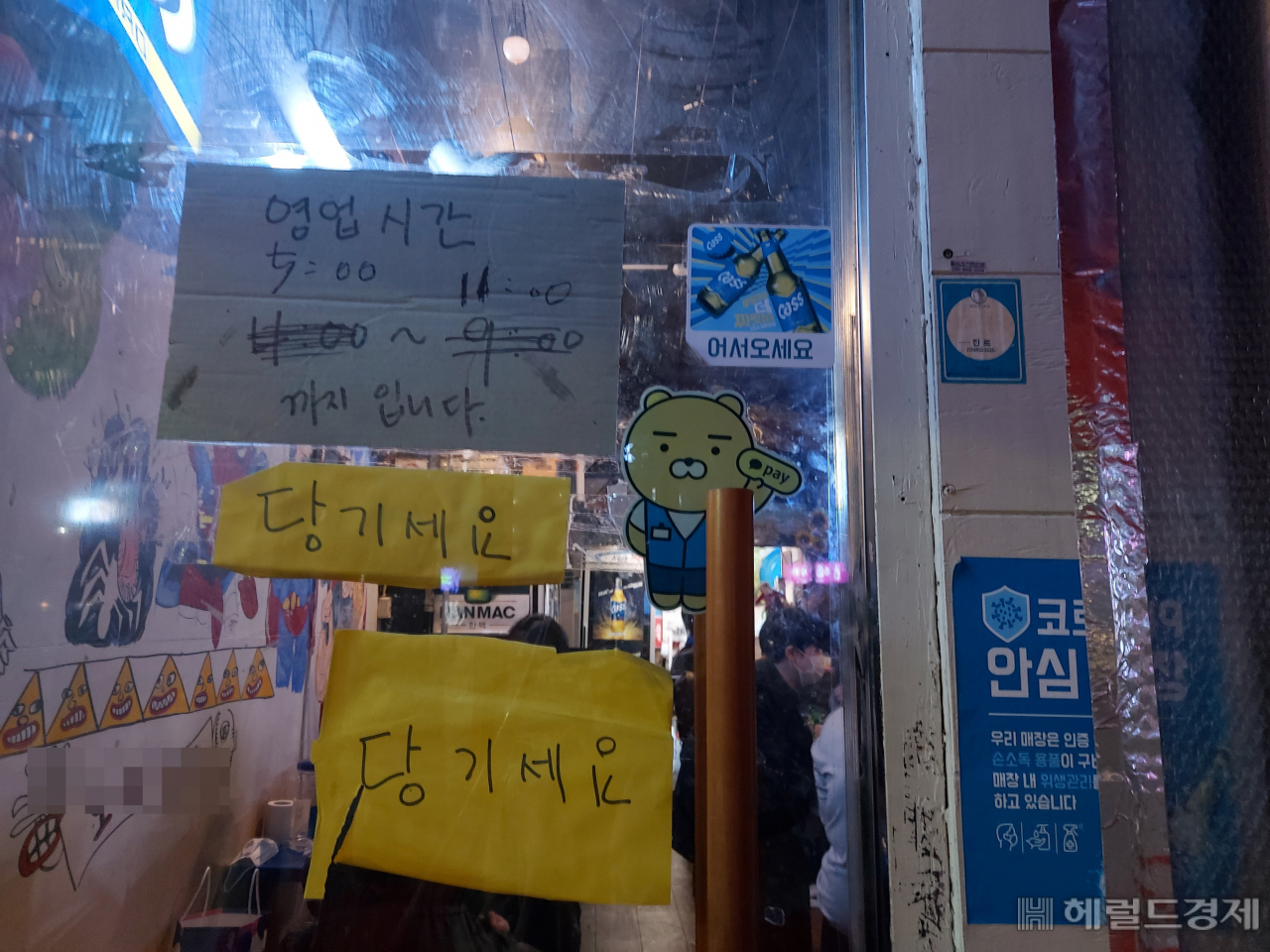 밤 12시까지 영업이 가능해진 첫날이었던 지난 4일. 서울 마포구에 위치한 한 실내 포장마차의 출입구. 밤 12시까지 영업이 가능하지만 영업시간 안내판은 바뀌지 않은채 붙어 있다. 김희량 기자