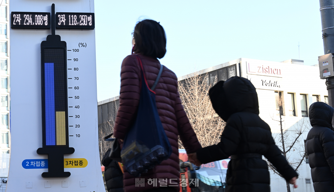 서울 광진구 자양사거리에 설치된 코로나19 백신 접종률 온도탑 앞으로 시민들이 지나가고 있다. [박해묵 기자]
