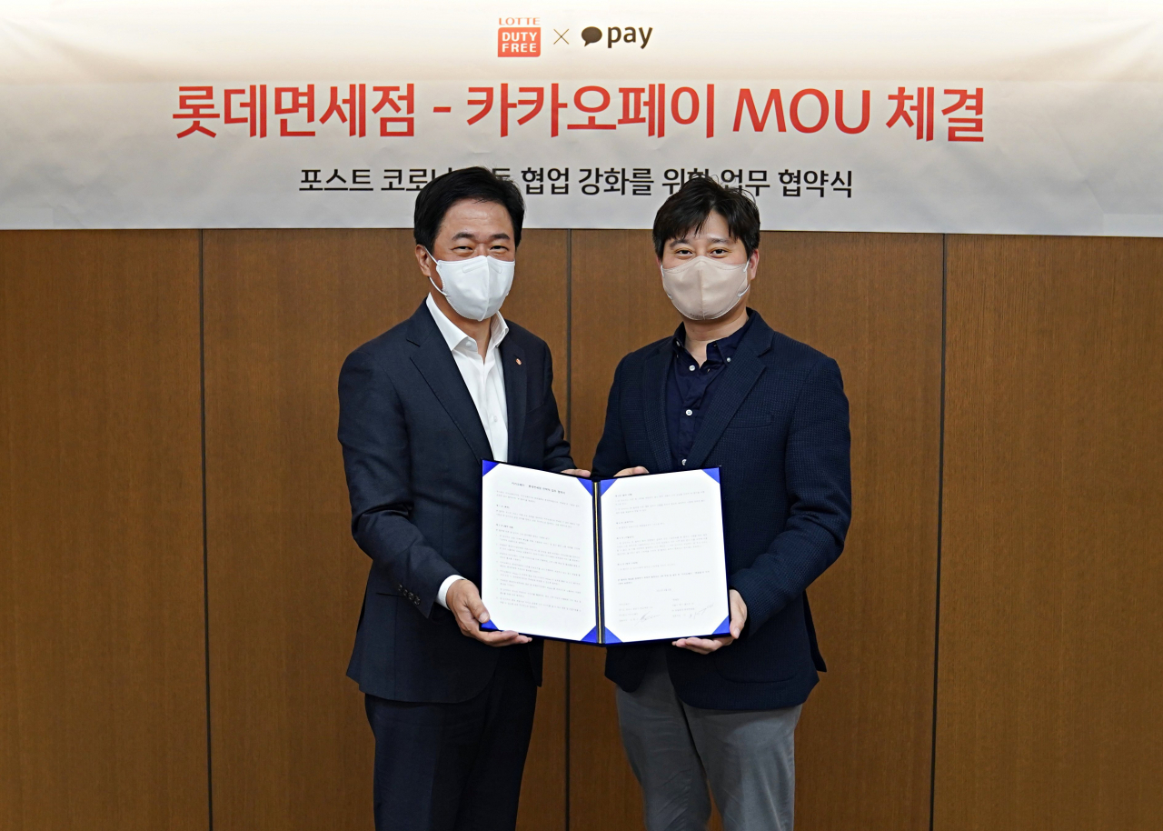롯데면세점이 '카카오페이'와 전략적 파트너십을 위한 양해각서(MOU)를 체결했다고 7일 밝혔다. 이갑 롯데면세점 대표이사(사진 좌측)와 신원근 카카오페이 대표이사가 업무협약식 기념사진을 촬영하고 있다. [롯데면세점 제공]