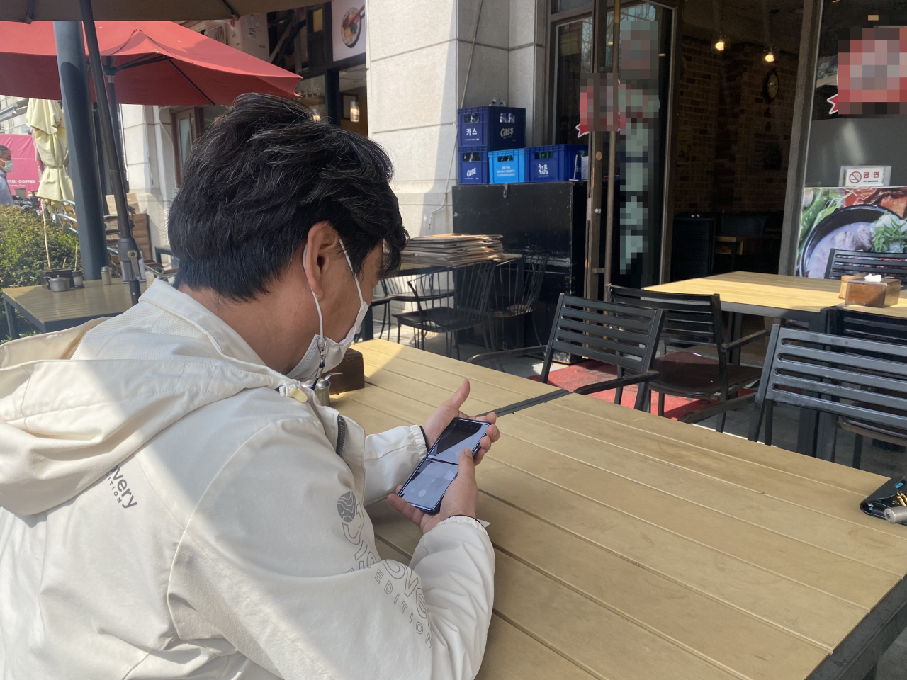 지난 4일 오후 2시께 서울 영등포구 여의도에서 17년째 순댓국밥집을 운영하는 자영업자 이모(56) 씨가 휴대전화를 들여다보고 있다. 신주희 기자