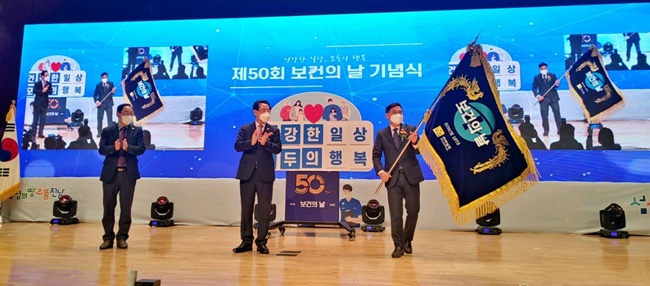 제50회 보건의 날 기념식에서 차기 개최도시로 확정된 순천시보건소 이기정 소장이 대회기를 흔들고 있다.