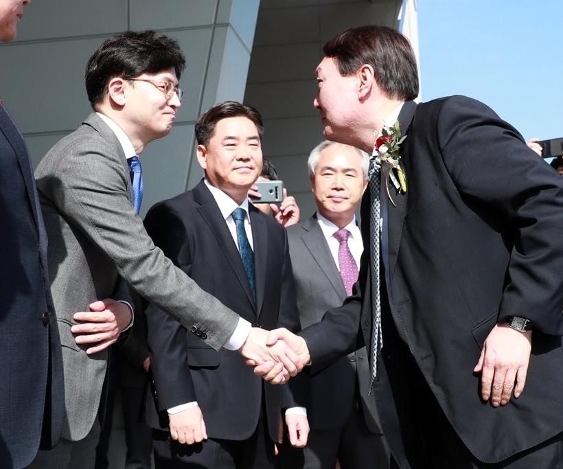In this photo taken Feb. 13, 2020, Han Dong-hoon shakes hands then-Prosecutor General Yoon Suk-yeol. (Yonhap)