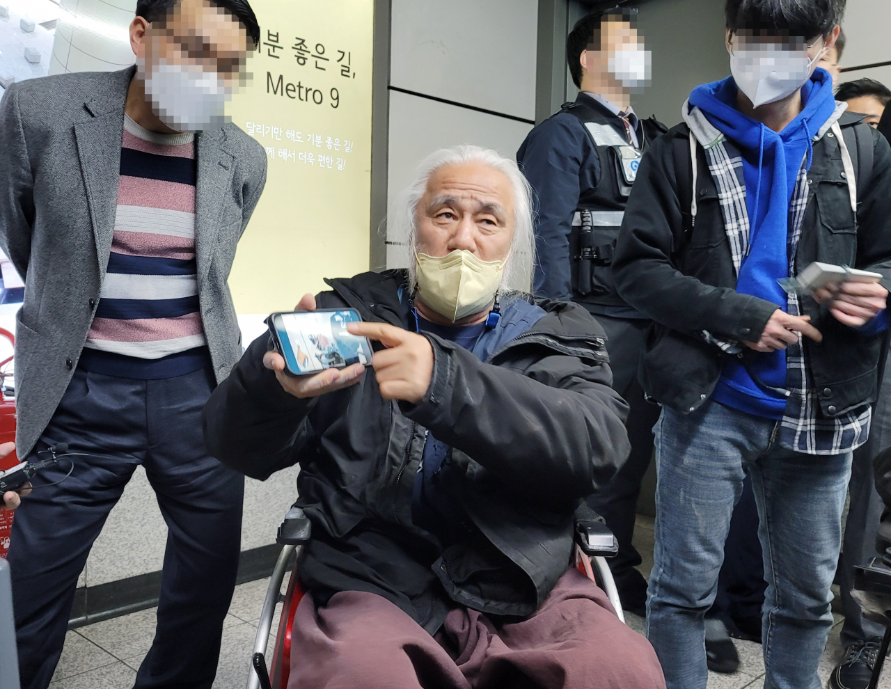 박경석 전국장애인차별철폐연대 상임공동대표가 지난 7일 오후 전동휠체어 사고가 발생한 서울 강서구 지하철 9호선 양천향교역에서 취재진에게 사고가 난 휠체어 사진을 보여주고 있다. 같은 날 낮 12시55분께 전동휠체어에 탑승한 채 에스컬레이터를 이용하던 50대 남성이 뒤로 넘어져 병원으로 이송됐지만 숨졌다. [연합]