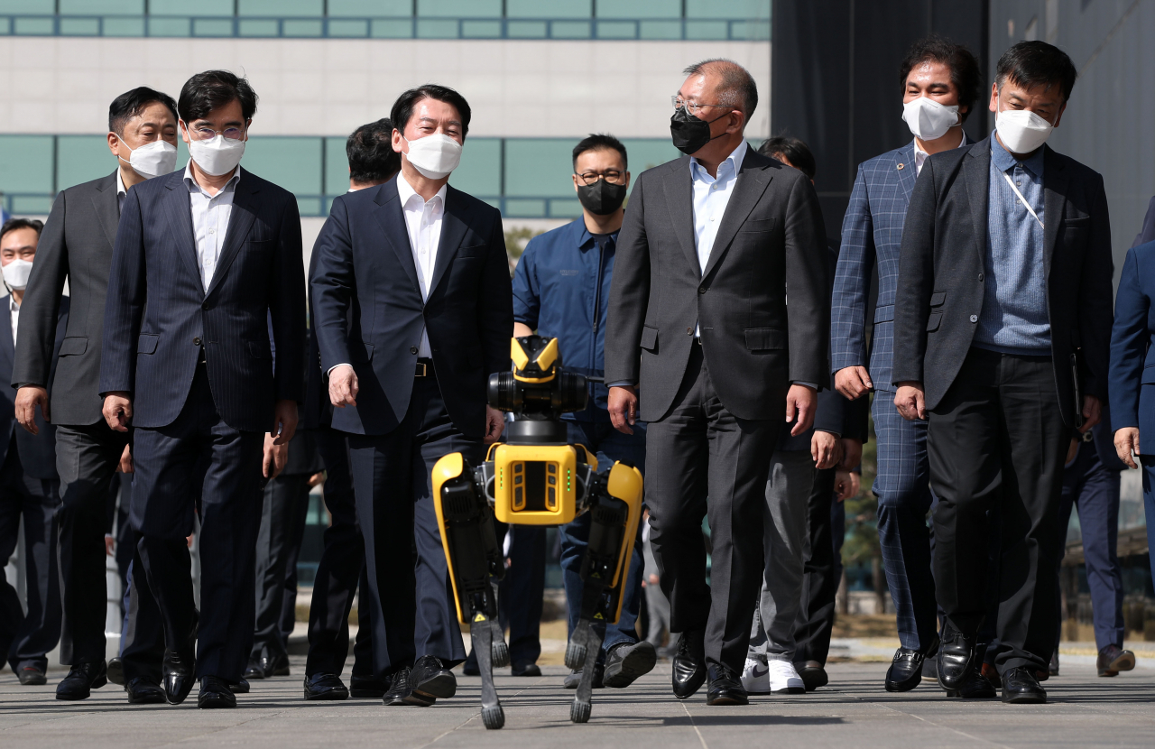 안철수 대통령직위원회 위원장이 8일 경기도 화성 현대자동차·기아 기술연구소를 방문, 정의선 현대자동차그룹 회장과 로봇개 스팟 에스코트를 받으며 현대디자인동으로 이동하고 있다. [연합]