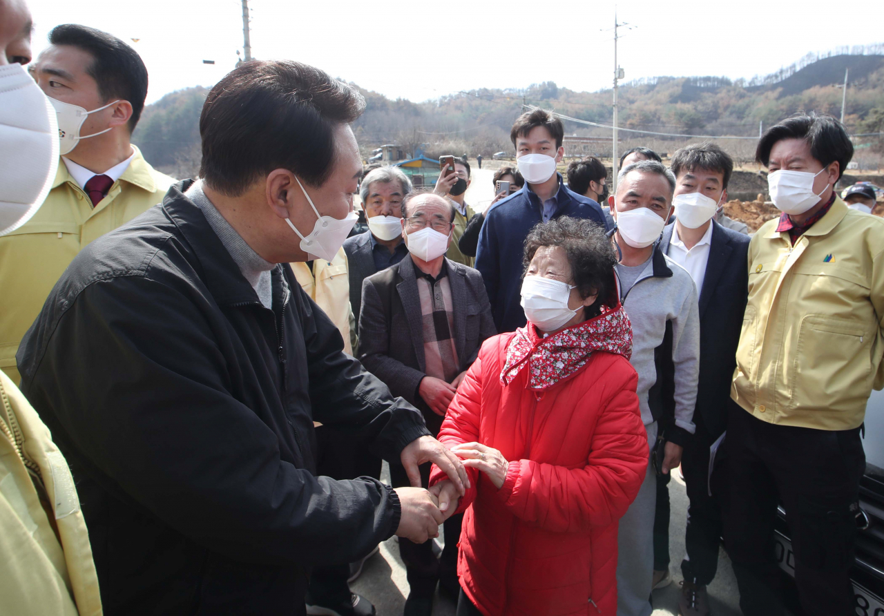 윤석열 대통령 당선인이 지난달 15일 경북 울진군 북면 검성리 산불피해현장을 방문해 피해지역 주민들과 인사하고 있다. [국회사진기자단]
