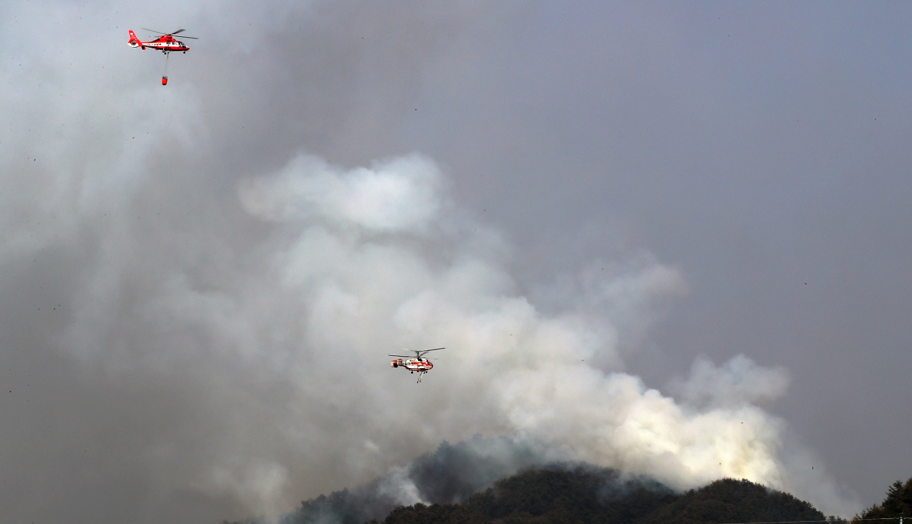 Firefighting helicopters are in operation to drop water on wildfires in Yanggu, northeastern South Korea, on Monday. (Yonhap)
