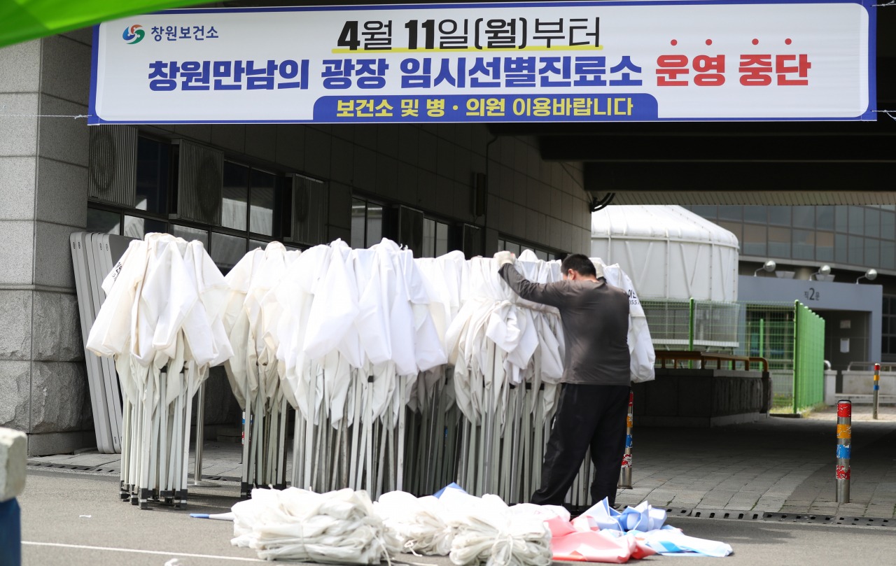 12일 오전 경남 창원시 성산구 창원 만남의광장에 마련된 '코로나19 임시선별검사소'에서 관계자들이 시설을 철거하고 있다. [ 연합]