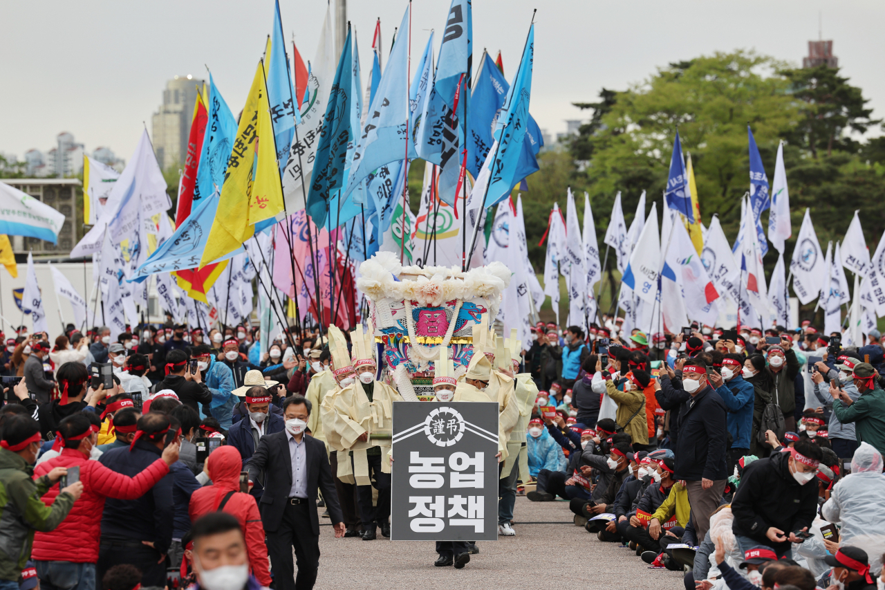 전국농민회총연맹(전농) 관계자들이 지난13일 오후 서울 여의도공원 문화의마당에서 포괄적·점진적 환태평양 경제동반자 협정(CPTPP) 가입 저지 전국농어민 집회에서 깃발 입장과 함께 상복 퍼포먼스를 하고 있다.