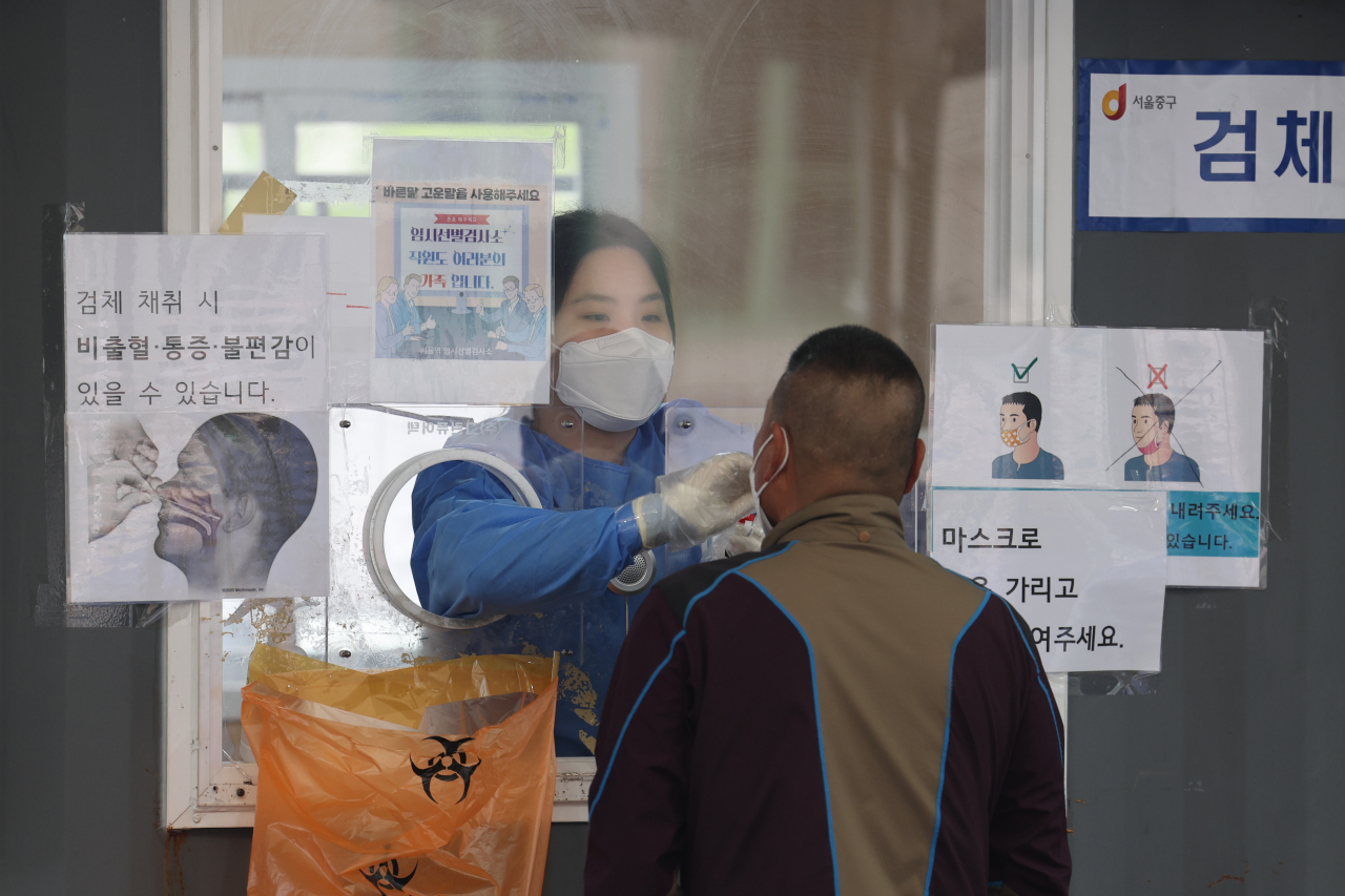 코로나19 확진자 수가 감소세를 보이고 있는 가운데 13일 오전 서울역 선별검사소에서 의료진이 검체채취를 하고 있다. [연합]