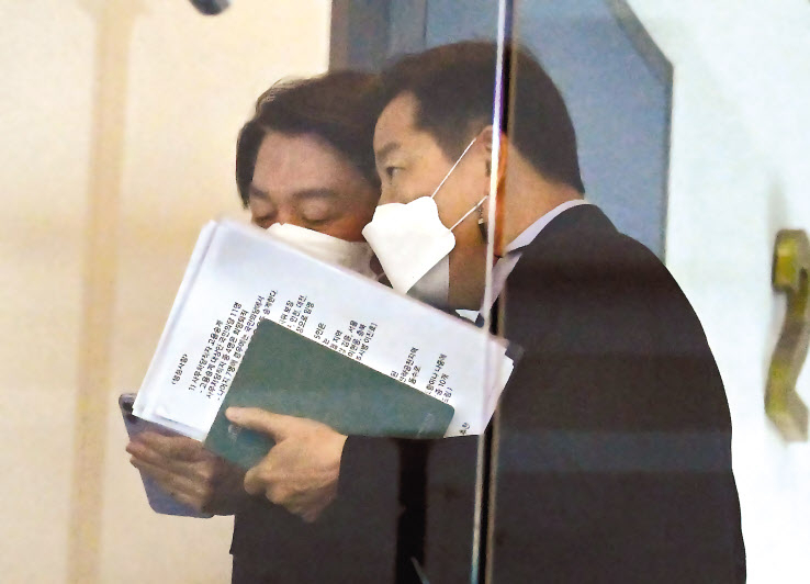 안철수 대통령직인수위원장이 15일 오전 서울 종로구 통의동 대통령직인수위원회에서 열린 간사단 회의 참석하기 위해 관계자와 대화를 하며 이동하고 있다. 관계자의 손에 국민의힘-국민의당 합당 논의 관련 문서로 보이는 서류(오른쪽 확대사진)가 들려져 있다. 문서엔 ‘합당 쟁점사항’이라는 문구와 국민의당은 고용승계 대상인 자당 사무처당직자 11명 중 7명의 고용승계를 국민의힘에 요청할 것이라는 내용이 적혀져 있다. 박해묵 기자