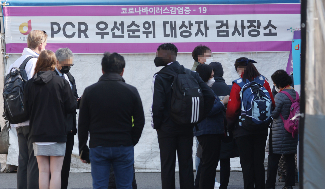 신종 코로나 바이러스 감염증 신규 확진자 수가 12만5846명을 기록한 15일 오전 서울역 광장 코로나19 선별진료소를 찾은 외국인들이 검사를 위해 대기하고 있다. [연합]