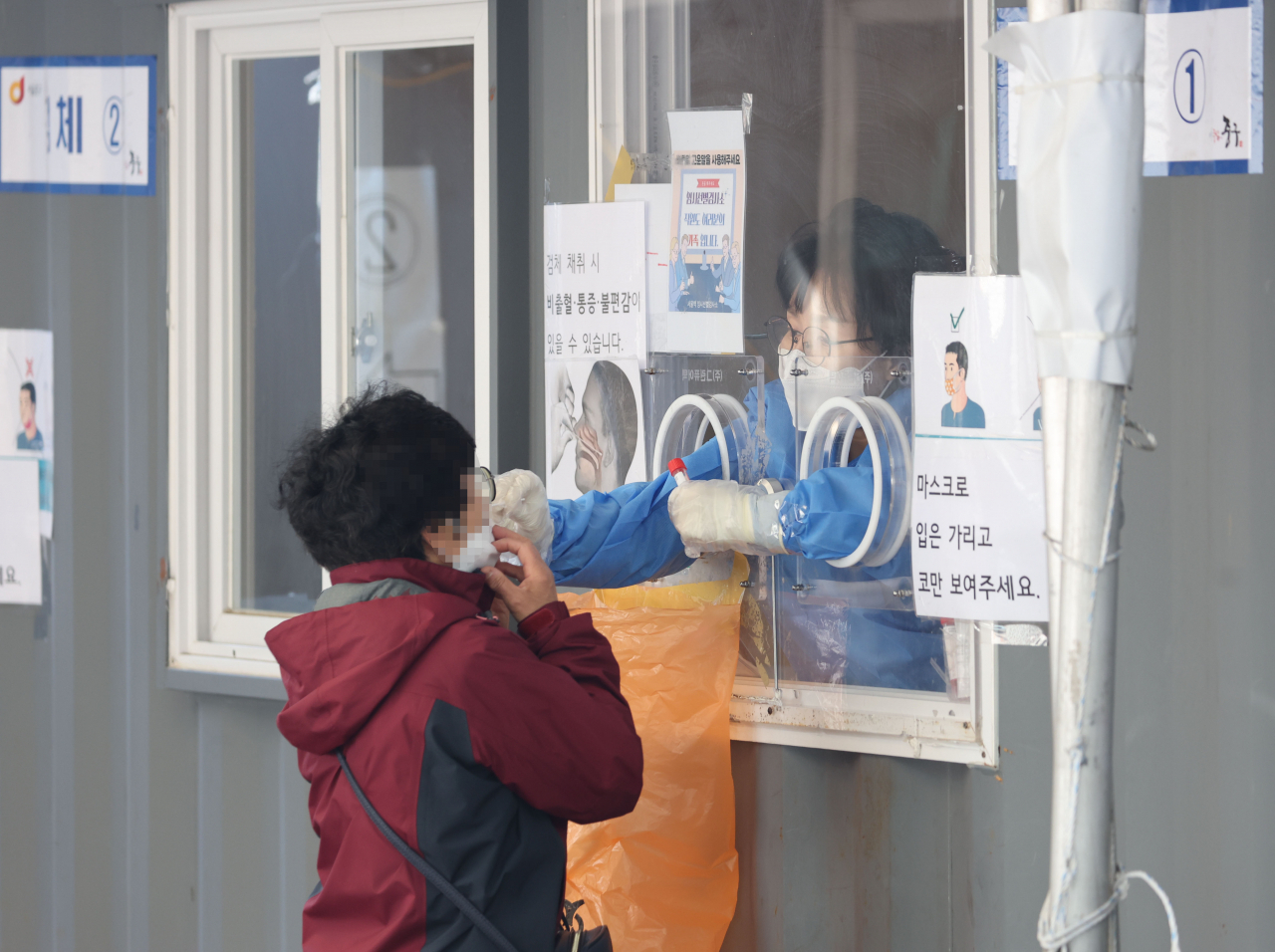 A citizen receives a COVID-19 test at a temporary testing center in front of Seoul Station on Friday. (Yonhap)