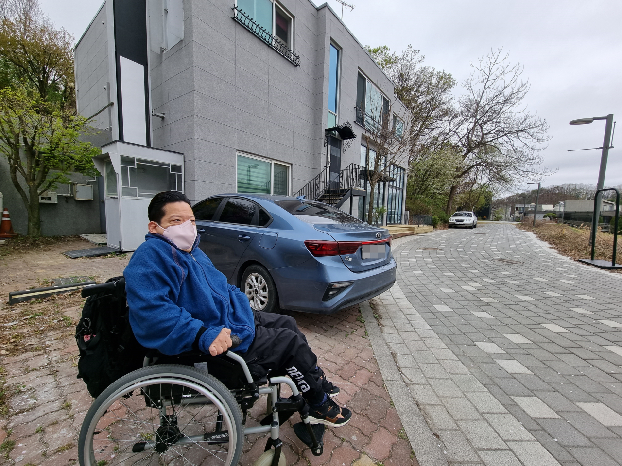 지난 14일 오전 10시30분께 뇌병변장애인 이성우(53) 씨가 경기 파주시 헤이리예술마을에 위치한 자택 앞에서 장애인 콜택시를 기다리는 모습. 김영철 기자