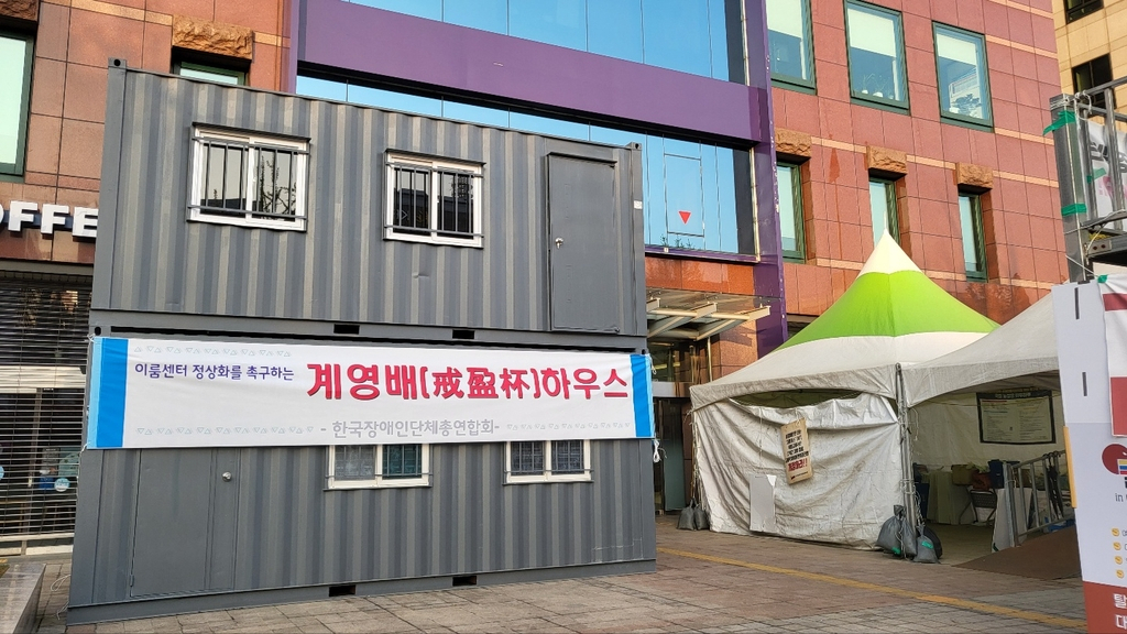 보수 장애인단체가 ‘전장연’의 지하철 시위를 비판하며 농성장 인근에 세운 컨테이너. [연합]