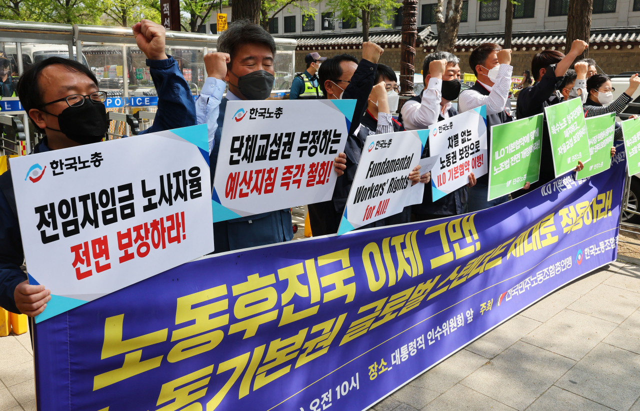 20일 오전 서울 종로구 대통령 인수위원회 앞에서 민주노총·한국노총 주최로 열린 ILO기본협약 발효에 따른 양 노총 기자회견에서 참가자들이 구호를 외치고 있다. [연합]