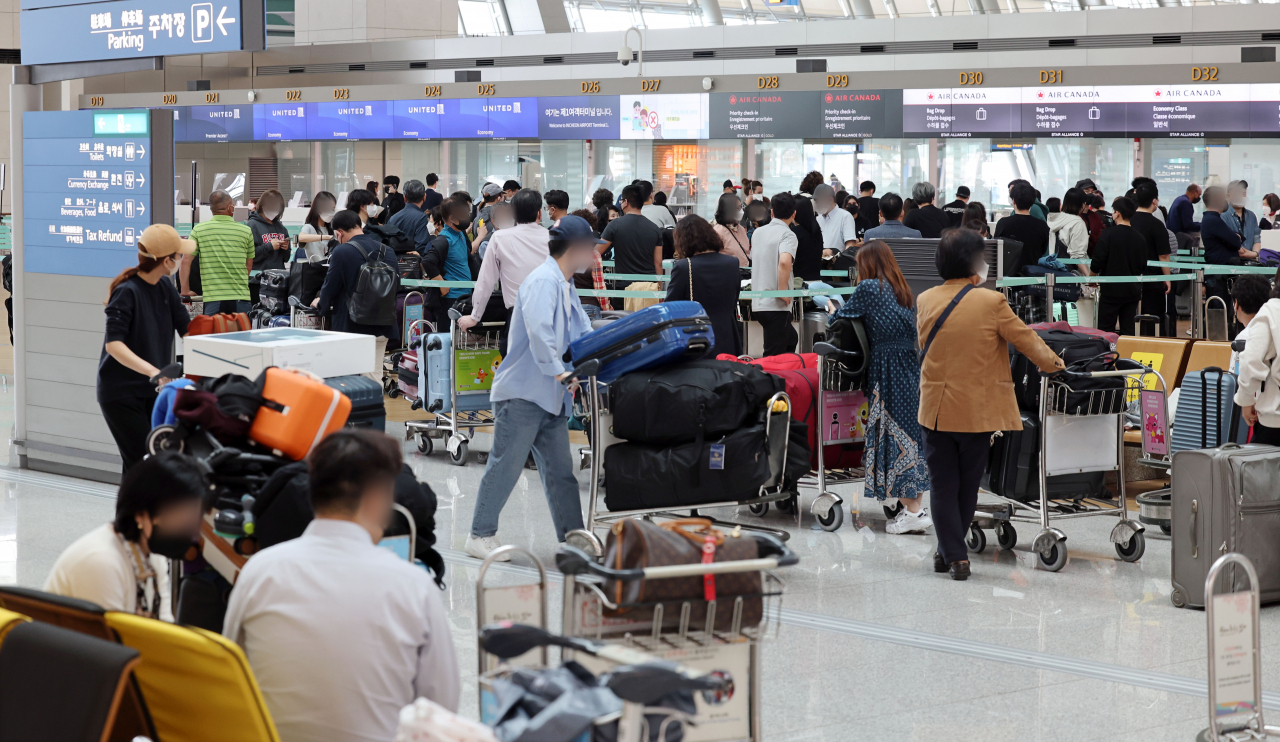 11일 오후 인천국제공항 제1터미널 출국장에서 비행기에 탑승하려는 출국자들이 탑승 수속을 위해 줄을 서고 있다. [연합]