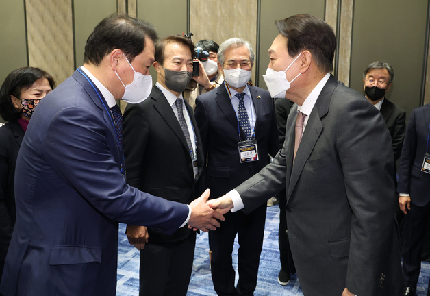 윤석열 20대 대통령 당선인(오른쪽)이 지난 18일 오후 서울 종로구 포시즌스 호텔에서 열린 서울국제포럼(SFIA) ‘복합위기 극복과 글로벌 중추국가 도약을 향한 경제안보 구상’ 정책 간담회에서 대한상의 회장인 최태원 SK그룹 회장과 악수를 나누고 있다. [인수위사진기자단]