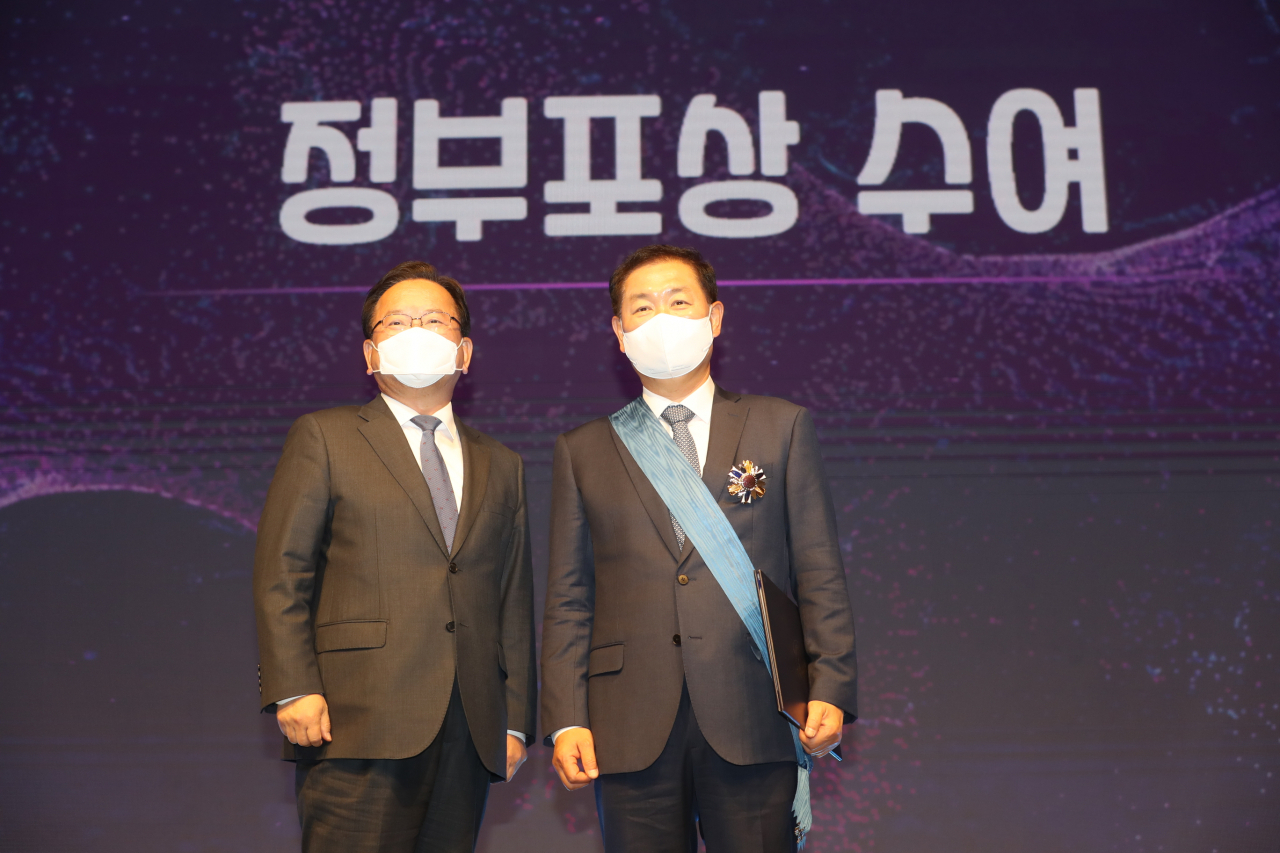 김부겸 국무총리가 21일 오후 서울 강남구 한국과학기술회관에서 열린 '2022 과학정보통신의 날 기념식' 에 참석해 한종희 삼성전자 대표이사에게 과학기술훈장 창조장을 시상하고 있다.[과기정통부 제공]