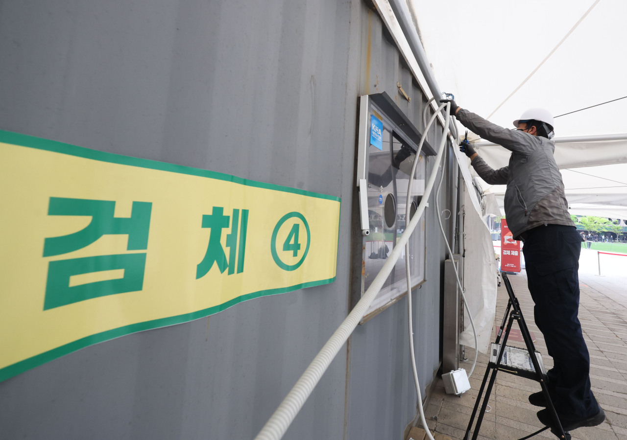 Workers disassemble a makeshift COVID testing booth in front of Seoul Station on Friday. (Yonhapa)