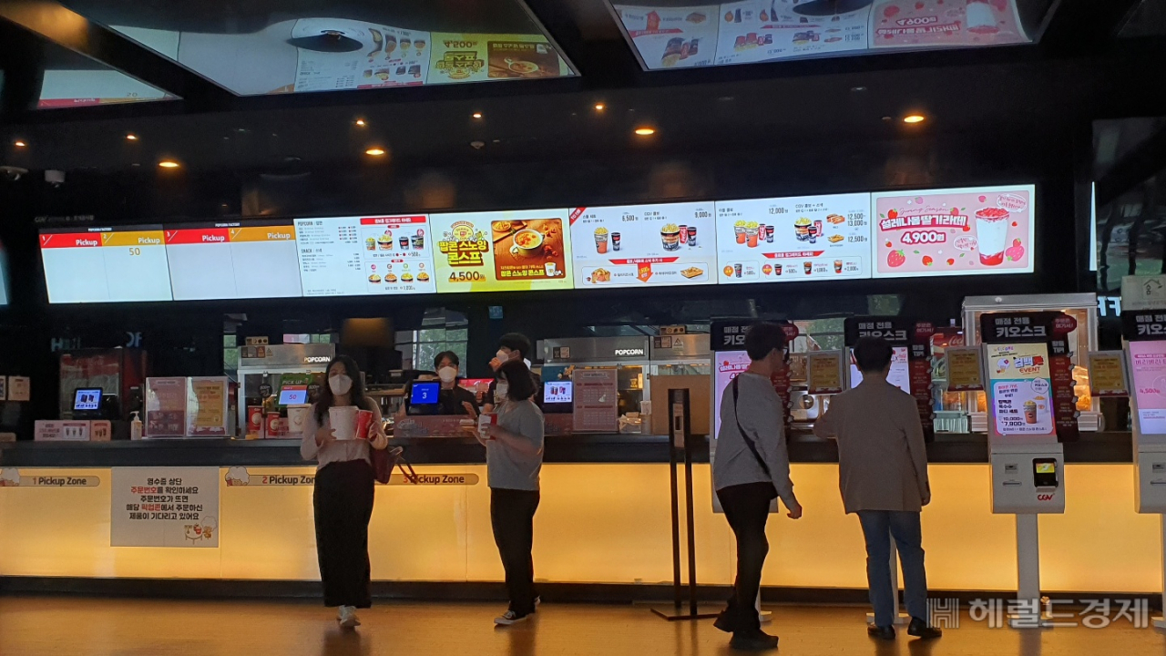 극장을 찾은 고객들이 영화예매와 팝콘 등 간식거리를 주문하고 있다. 거리두기가 사실상 해제되면서 영화관에서도 콜라와 팝콘을 먹을 수 있게 됐다. 서인주 기자