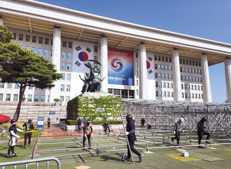 제20대 대통령 취임식을 꼭 두 주 앞둔 가운데, 26일 오전 국회 본청 앞에서 관계자들이 취임 행사 준비를 위한 기초 가설물을 세우고 있다. [국회사진기자단]