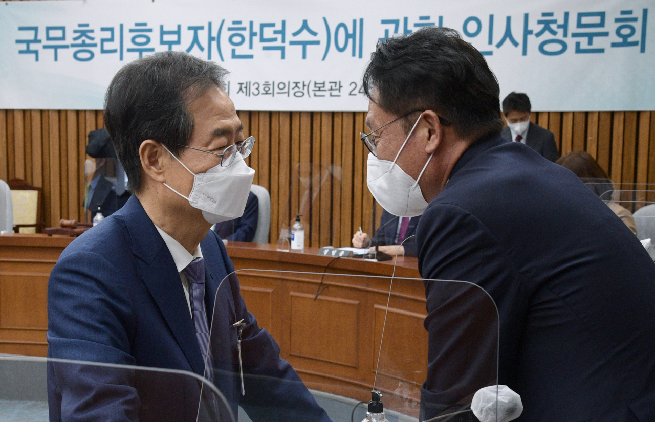 한덕수 국무총리 후보자(왼쪽)와 정의당 배진교 원내대표가 26일 오전 서울 여의도 국회에서 열린 인사청문회에서 대화를 나누고 있다. 이상섭 기자