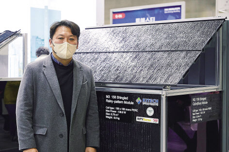 정재환 박사가 빗물이 흘러내리는 패턴의 슁글드 태양광 패널을 보여주고 있다. [한국생산기술연구원 제공]