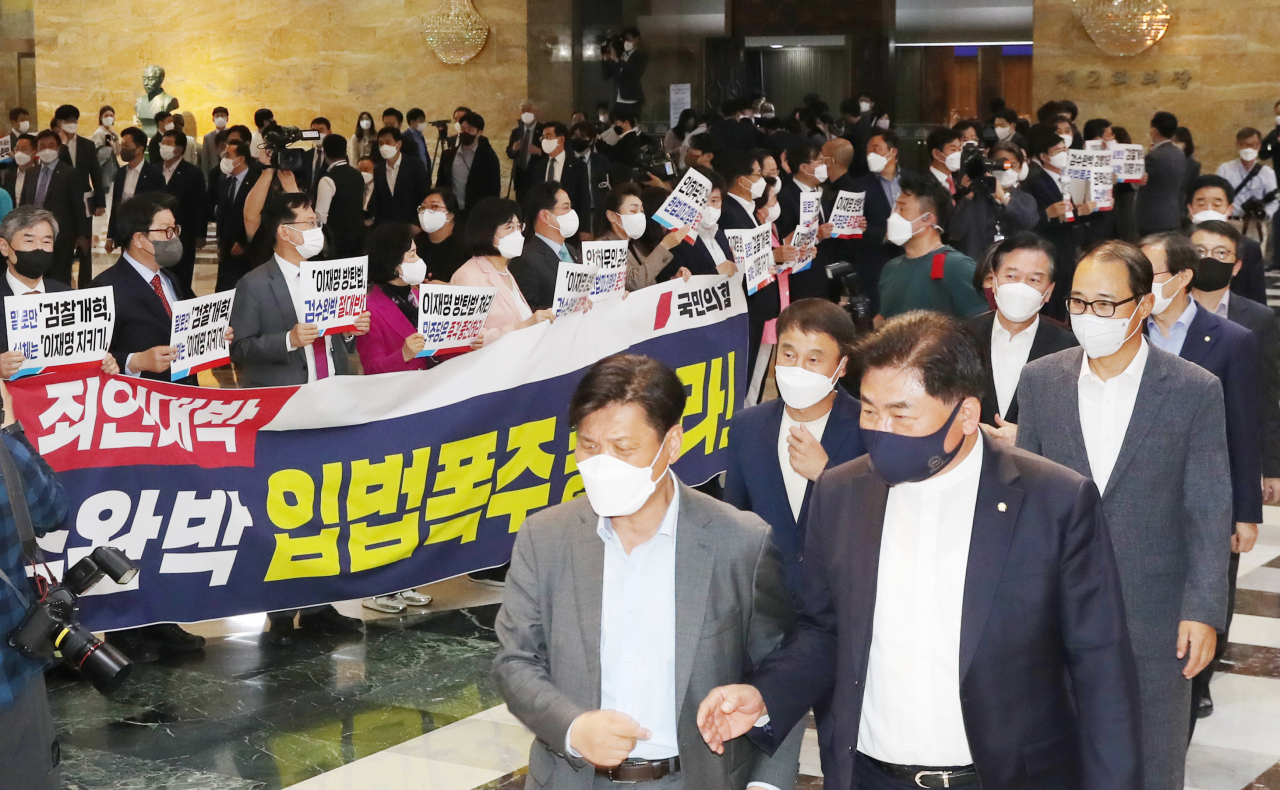 27일 국회 로텐더홀에서 국민의힘 의원들이 본회의장으로 입장하는 더불어민주당 의원들을 향해 검찰 수사권과 기소권 분리 법안 반대 구호를 외치고있다. 연합뉴스